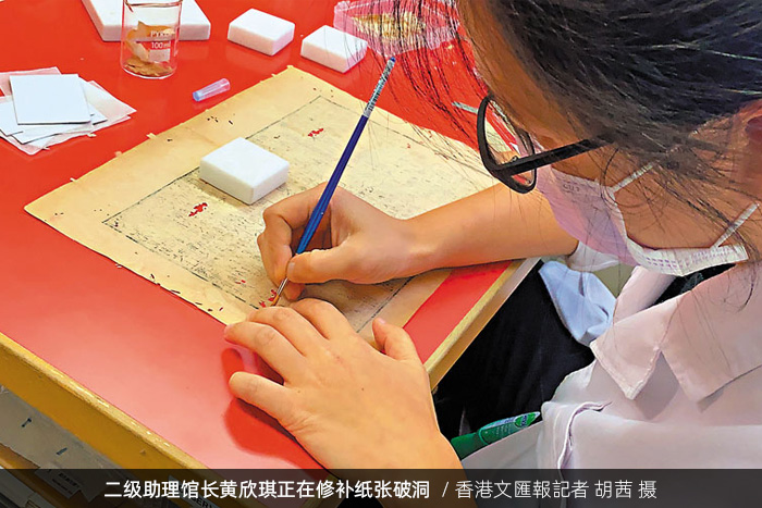 香港中央圖書館二級(jí)助理館長黃欣琪正在修補(bǔ)紙張破洞/香港文匯報(bào)記者 胡茜 攝